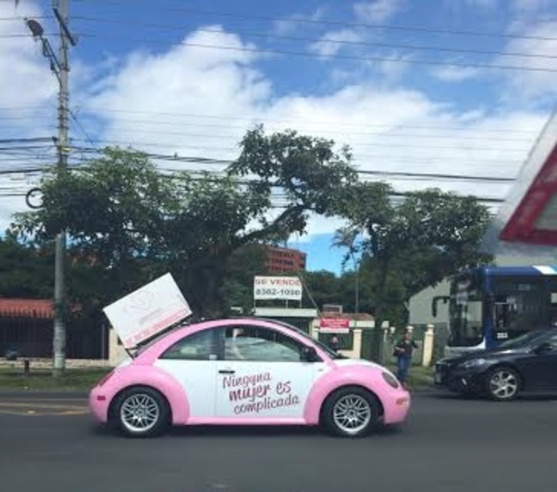 Pink-and-white Volkswagen Beatles, or what some described as looking like “Barbie cars” could be seen driving around the capital city over the weekend and Monday promoting the new bank. The bank's slogan, which is painted on the doors, reads "No woman is complicated." (Photo courtesy of CRHoy.com)