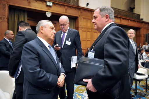 Costa Rica's agent to the court Edgar Ugalde-Alvarez (L) speaks with Nicaragua's agent Carlos Jorge Arguellos Gomez prior to a hearing at the International Court of Justice in The Hague on October 14, 2013. Costa Rica is asking the International Court of Justice to call a halt to the construction by Nicaragua of two canals near the two countries' border. AFP PHOTO/MAUDE BRULARD