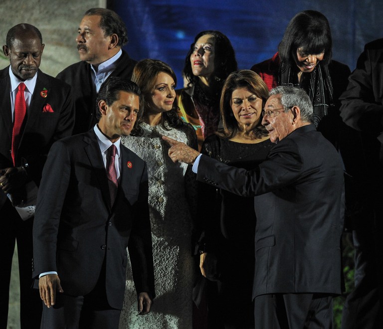 Cuban President Raul Castro (R) talks with Mexican President Enrique Pena Nieto (L), Mexican first lady Angelica Rivera (2nd L) and Costa Rican President Laura Chinchilla during the family picture of members of the Latin American and Caribbean States (CELAC) on January 28, 2014 at Revolution Palace in Havana. At back L-R, Saint Kitts and Nevis Denzil Douglas, Nicaraguan President Daniel Ortega, his wife Rosario Murillo and Jamaican President Portia Simpson-Miller. AFP PHOTO/YAMIL LAGE
