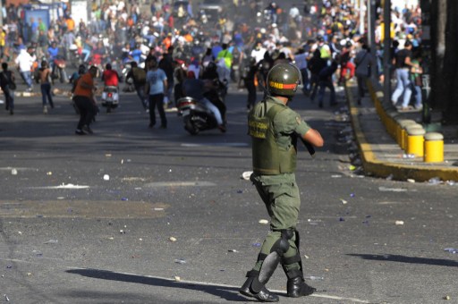 Students clash with National Guards members during an opposition demontration against the government of Venezuelan President Nicolas Maduro, in Caracas on February 12, 2014. Unidentified assailants on a motorcycle fired into a crowd of anti-government protesters, leaving at least two people wounded and a pro-government man dead. AFP PHOTO / LEO RAMIREZ